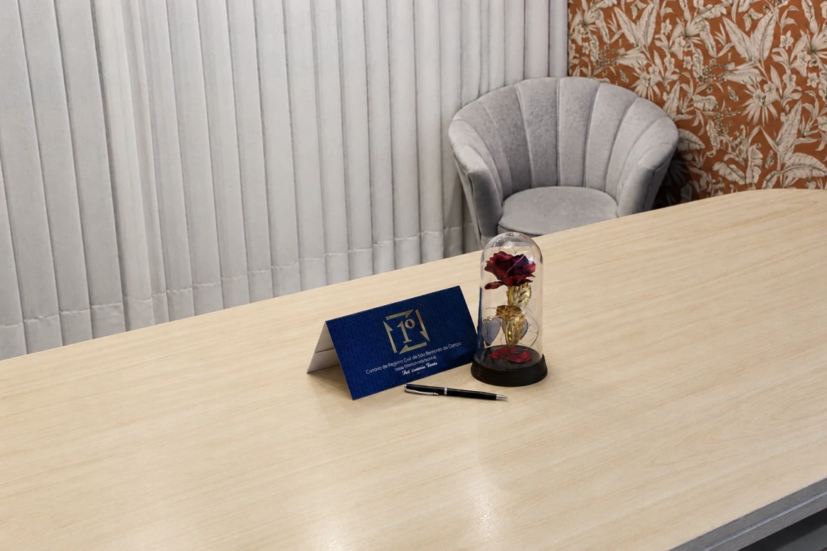 Mesa de casamento com poltrona, identificação do cartório e rosa decorativa