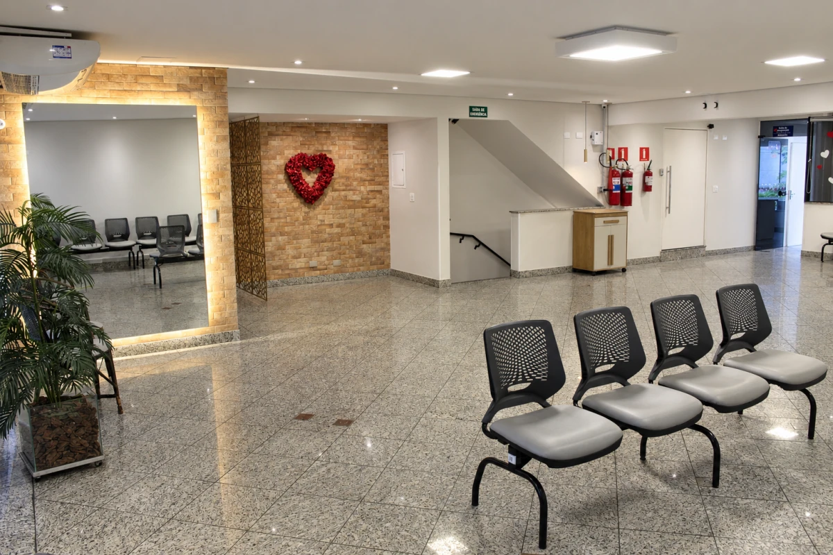 Área de espera com espelho iluminado e decoração de coração na parede