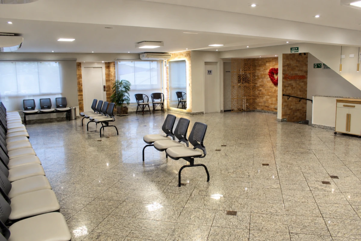 Sala de espera ampla, com fileiras de cadeiras e iluminação natural